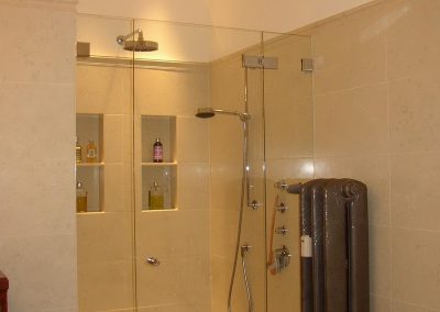 verglaster Duschstand mit gefliesten Shampoofächern