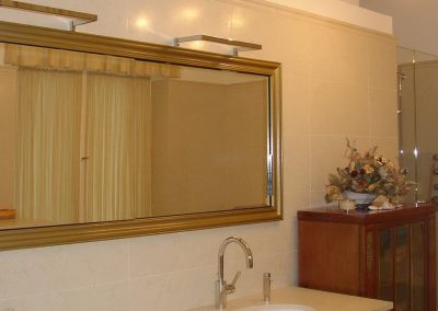goldgerahmter Wandspiegelschrank mit indirekter Beleuchtung